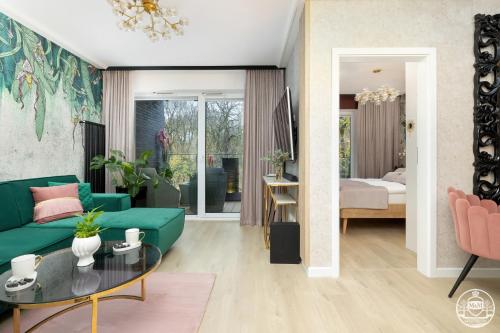 uma sala de estar com um sofá verde e uma mesa em Nadmorskie Tarasy-Spa&Art Bali, free parking -Apartments M&M em Kolobrzeg