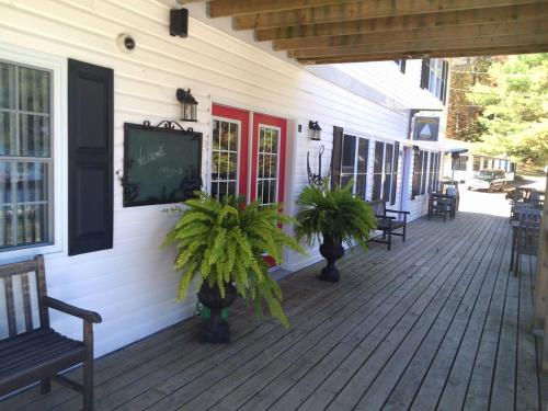 a porch with chairs and a chalkboard on a house at Little Hawk Resort & Marina in Algonquin Highlands