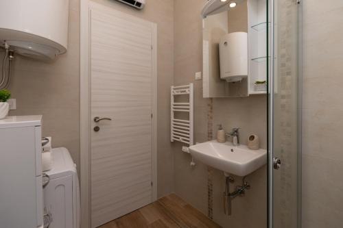 a small bathroom with a sink and a toilet at Bonintro Lux Apartment in Kotor