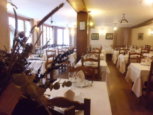 a dining room with white tables and chairs at Hotel Llacs De Cardos in Tavascan