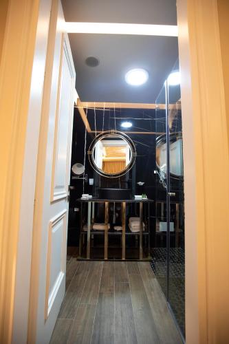 a hallway with a bathroom with a mirror and a door at Vila EKREM in Korçë