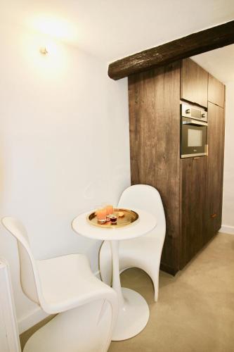 - une table blanche et 2 chaises blanches dans une pièce dans l'établissement Le Madeleine (duplex), à Aix-en-Provence