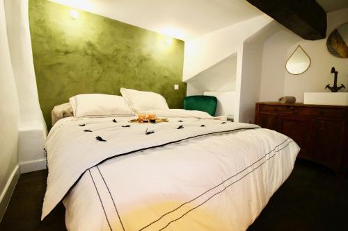 - une chambre dotée d'un grand lit blanc avec des bougies dans l'établissement Le Madeleine (duplex), à Aix-en-Provence