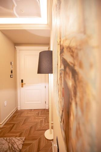 a hallway with a lamp and a painting on the wall at Vila EKREM in Korçë