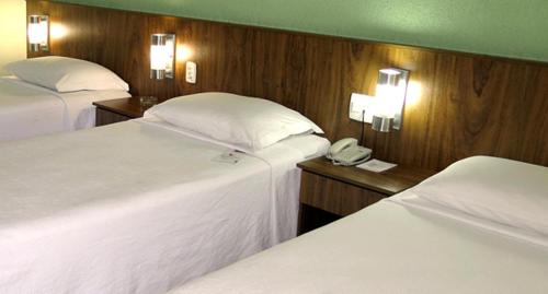 a hotel room with two beds and a phone at Steel Valley Economic Hotel in Ipatinga