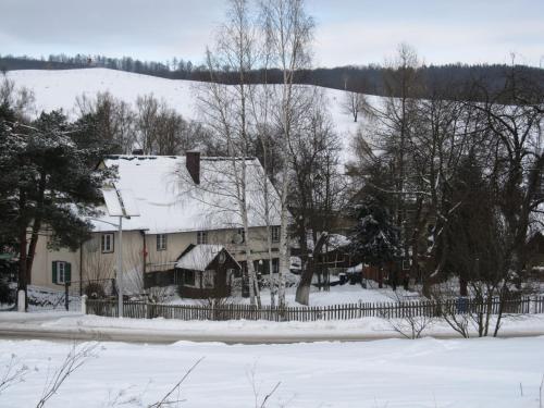 a house covered in snow with a fence at Chata za Górami in Zagórze Śląskie