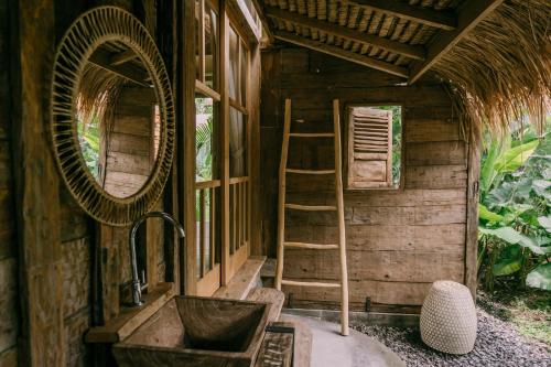 y baño con lavabo y espejo. en Wooden house at Semadi living en Sukawati