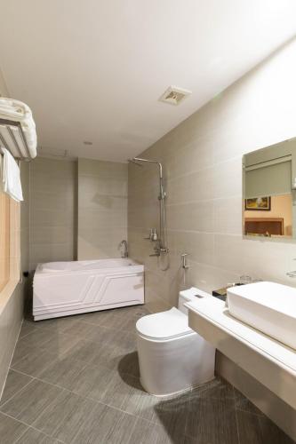 a bathroom with a tub and a toilet and a sink at BVM HOTEL in Ninh Binh