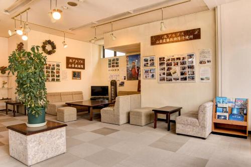 una sala de espera con sillas y mesas y una maceta en Hotel La Montagne Furuhata, en Hakuba