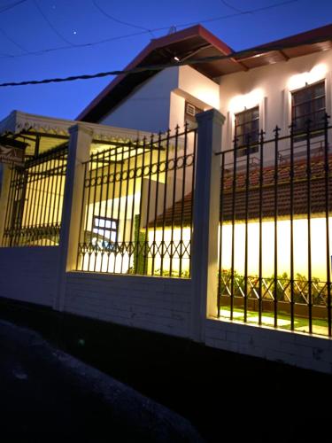 a white house with a gate at night at Dreamhome Stay in Kurseong