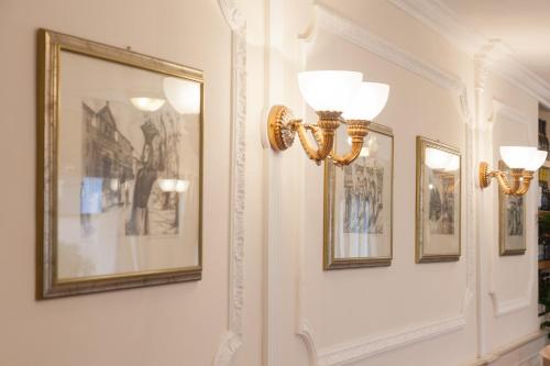 a hallway with framed pictures on the walls at Hotel Tahiti in Viareggio