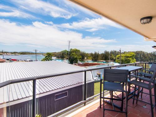 a balcony with a table and chairs and a view of the water at Horizons 8 on the lake in Forster