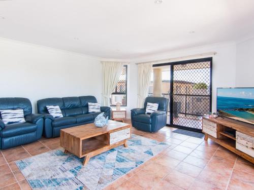 a living room with couches and a flat screen tv at Horizons 8 on the lake in Forster