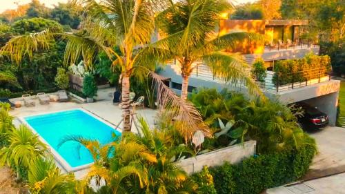 an aerial view of a house with a swimming pool and palm trees at Natural Villas Chiang Mai Luxury Private Pool in Chiang Mai