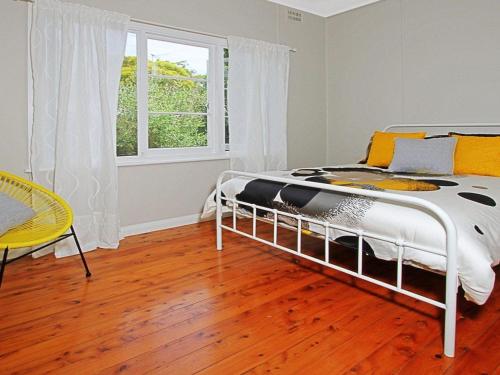 a bedroom with a bed and a table and a window at Culburra Sands in Culburra Beach