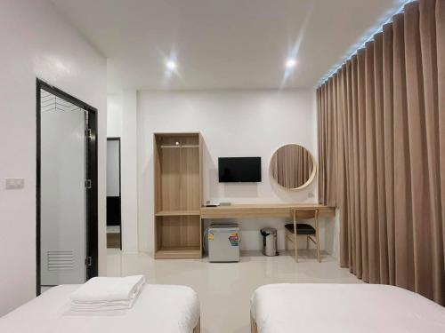 a room with two beds and a desk and a television at Topnorth Hotel Maesai in Mae Sai
