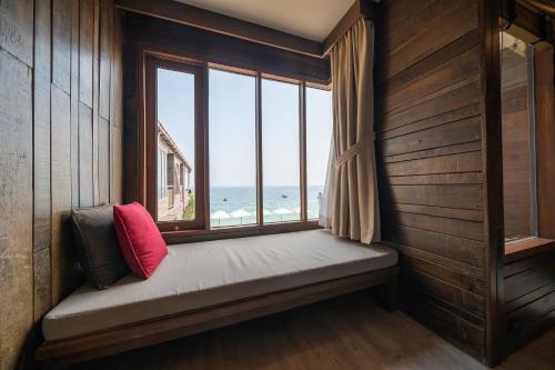 a window seat in a room with a view of the ocean at Baan Ploy Sea in Ko Samed