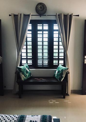 a window with a bench in front of a window at Tamarind Villa in Varkala