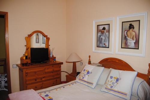 アガエテにあるCasa Mariluzのベッドルーム1室(ベッド1台、ドレッサー、テレビ付)