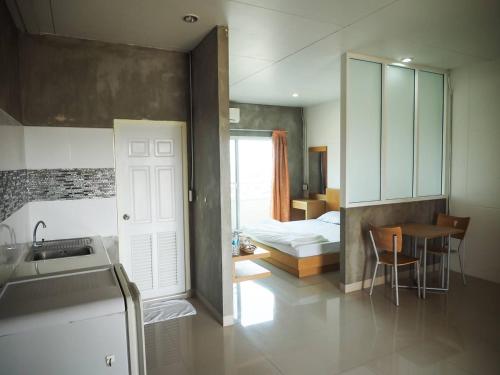 a kitchen and a bedroom with a bed and a table at The View Residence in Bangkok