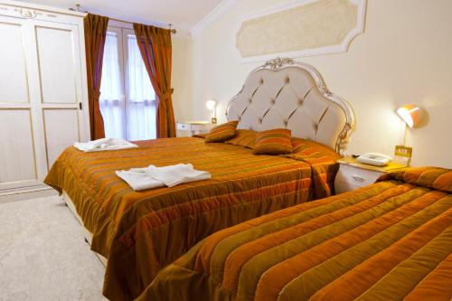 a hotel room with two beds and a window at Hotel Tahiti in Viareggio