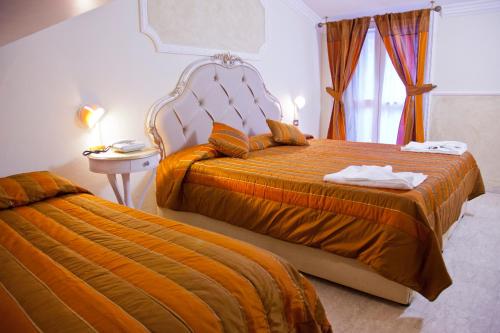 a hotel room with two beds and a window at Hotel Tahiti in Viareggio