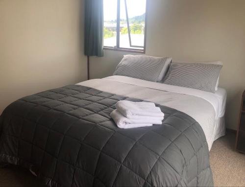 a bedroom with a bed with two towels on it at Solway House in Alexandra