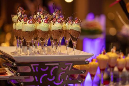 a group of wine glasses with whipped cream and candy at Earl's Regency Hotel in Kandy