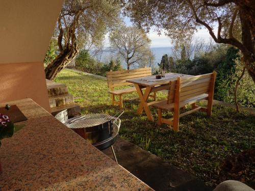 una mesa de picnic y un banco con vistas al océano en Nikić Apartments en Ulcinj