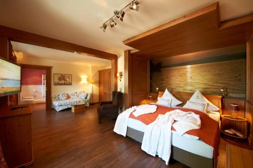 a hotel room with a bed and a living room at Garden-Hotel Reinhart in Prien am Chiemsee