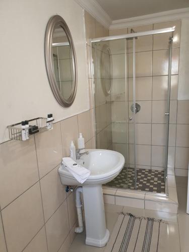 uma casa de banho com um lavatório e um chuveiro em Mminanoko Eco Guesthouse 