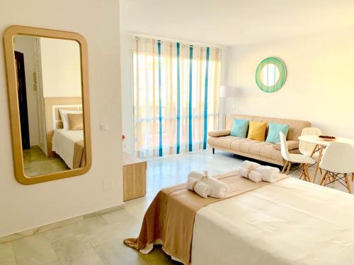 1 dormitorio con cama, espejo y sofá en Apartamento Marina Suite en Benalmádena