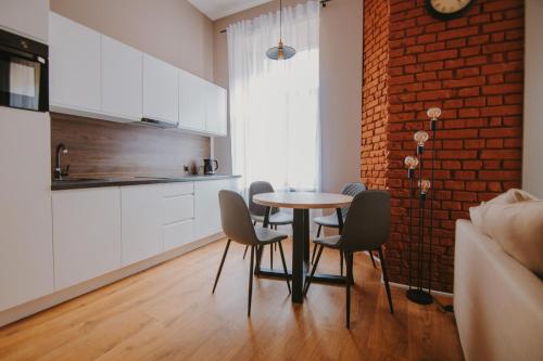 a kitchen and dining room with a table and chairs at Apartament Green - Piotrkowska 37 in Łódź