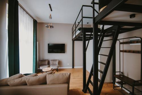 a living room with a loft bed and a couch at Apartament Green - Piotrkowska 37 in Łódź
