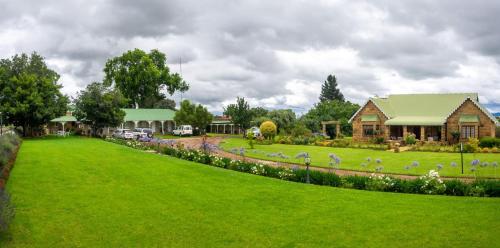 a large yard with a house and a green lawn at Fouriesburg Country Inn in Fouriesburg