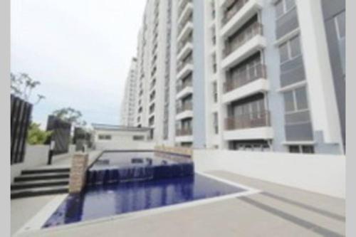 a building with a swimming pool in front of a building at @Sentrovue Homestay AFIQ near UiTM/Hosp PuncakAlam in Kuala Selangor