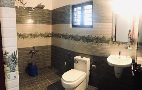 a bathroom with a toilet and a sink at Tamarind Villa in Varkala