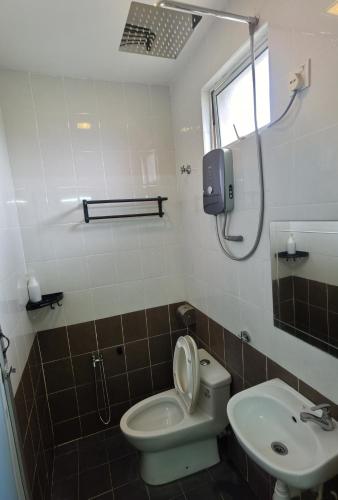 a bathroom with a toilet and a sink at NGS Hotel in Kuantan