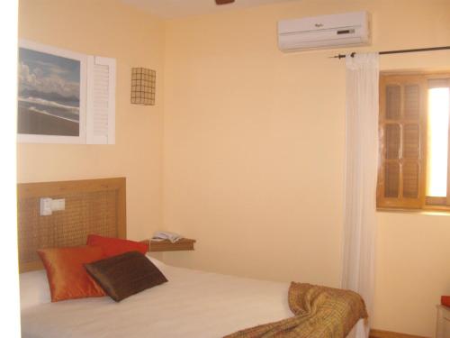a bedroom with a bed with red pillows at Kira's Boutique Hotel in Mindelo