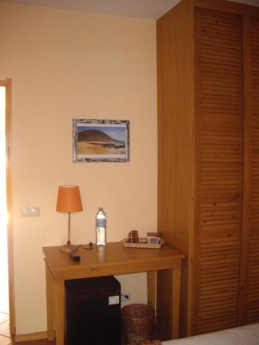 a room with a wooden desk with a lamp on it at Kira's Boutique Hotel in Mindelo