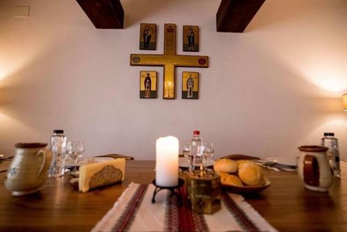 a table with a candle and a cross on the wall at Casa de Oaspeți Sfântul Nicolae in Iaşi