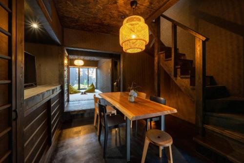 een eetkamer met een tafel en een trap bij Yoinotake Machiya House in Kyoto