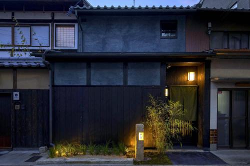 a black house with a sign in front of it at Yoinotake Machiya House in Kyoto