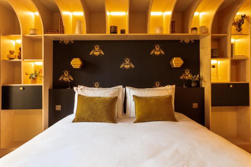 a bedroom with a bed with pillows and bats on the wall at Bonsoir Madame in Paris