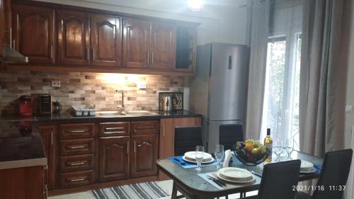 a kitchen with wooden cabinets and a table with a bowl of fruit at Miriam Luxury apartment in Zakynthos Town