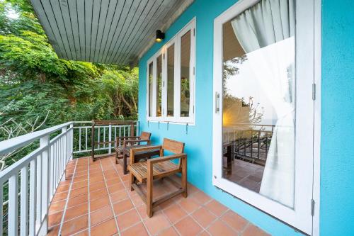 a balcony with a table and benches on a blue house at Aqua Beads Samed in Ko Samed