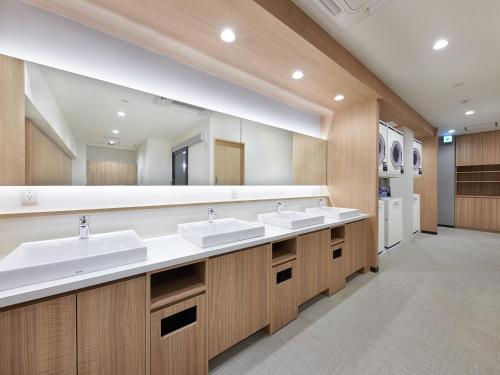uma casa de banho com 2 lavatórios e um espelho grande em Smart Stay SHIZUKU Shinagawa-Oimachi em Tóquio