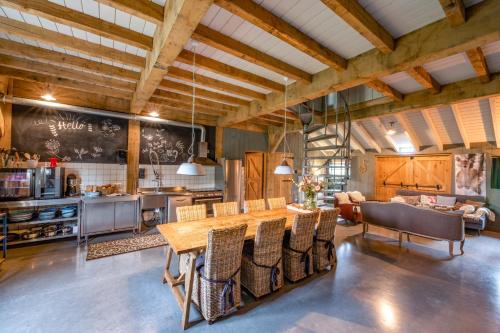 une cuisine avec une grande table et des chaises en bois dans l'établissement De Steltenberg in de Betuwe, à Zoelen