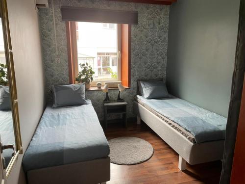 a small room with two beds and a window at Rymlig lägnhet med 2 sovrum in Oxie