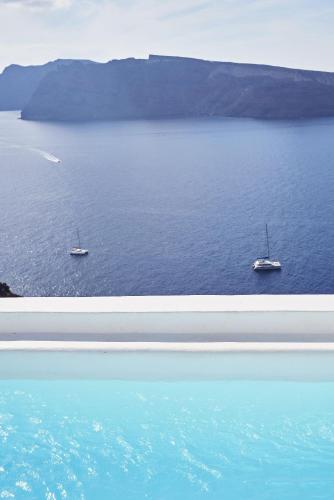 two boats in a large body of water at Charisma Suites in Oia